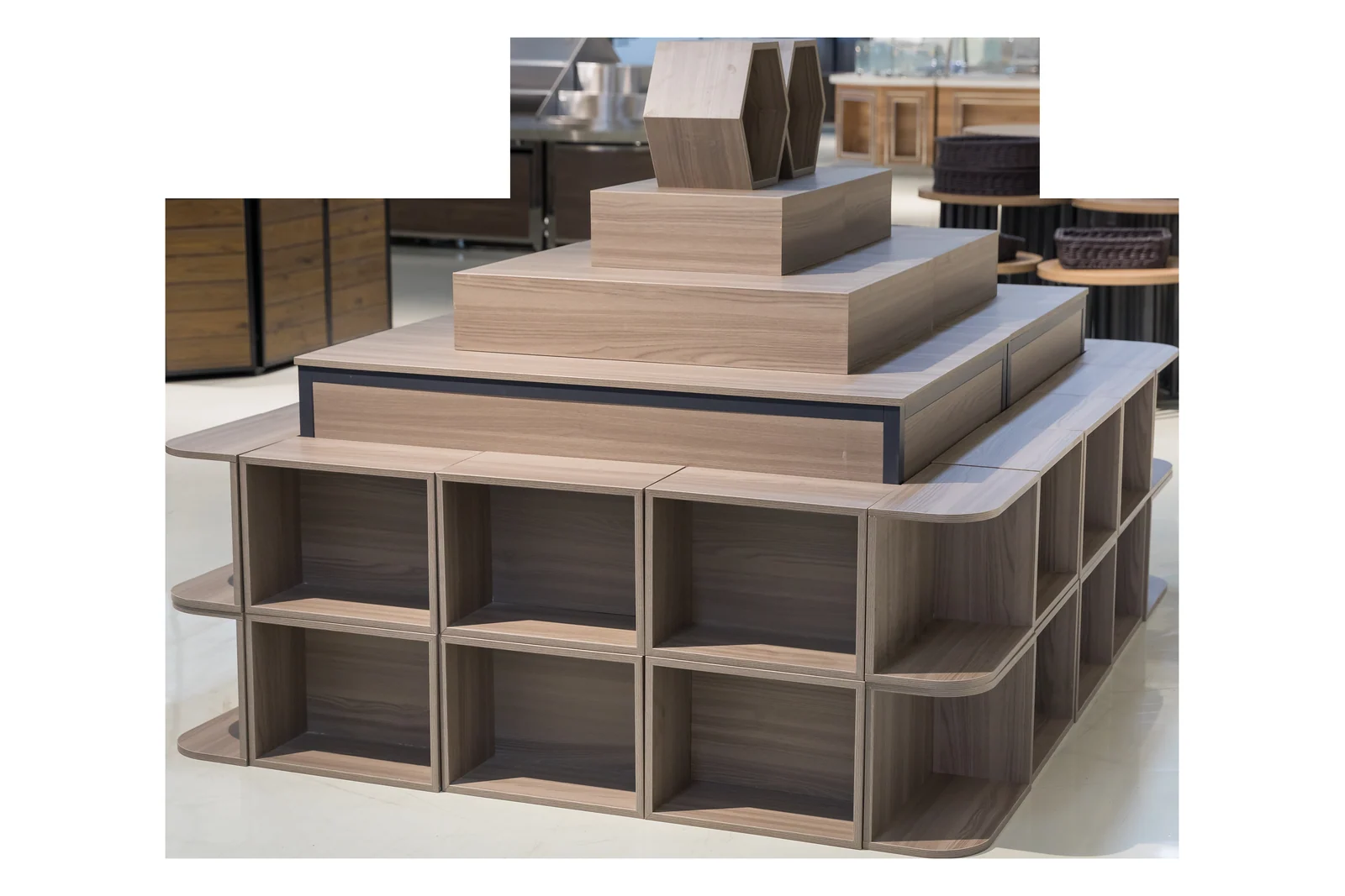 A tiered timber promotion table with open compartments through the base