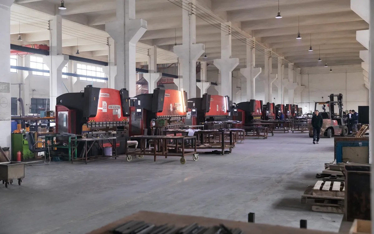 Crated store fixtures staged along an aisle of the Keshun workshop in Changshu before shipping