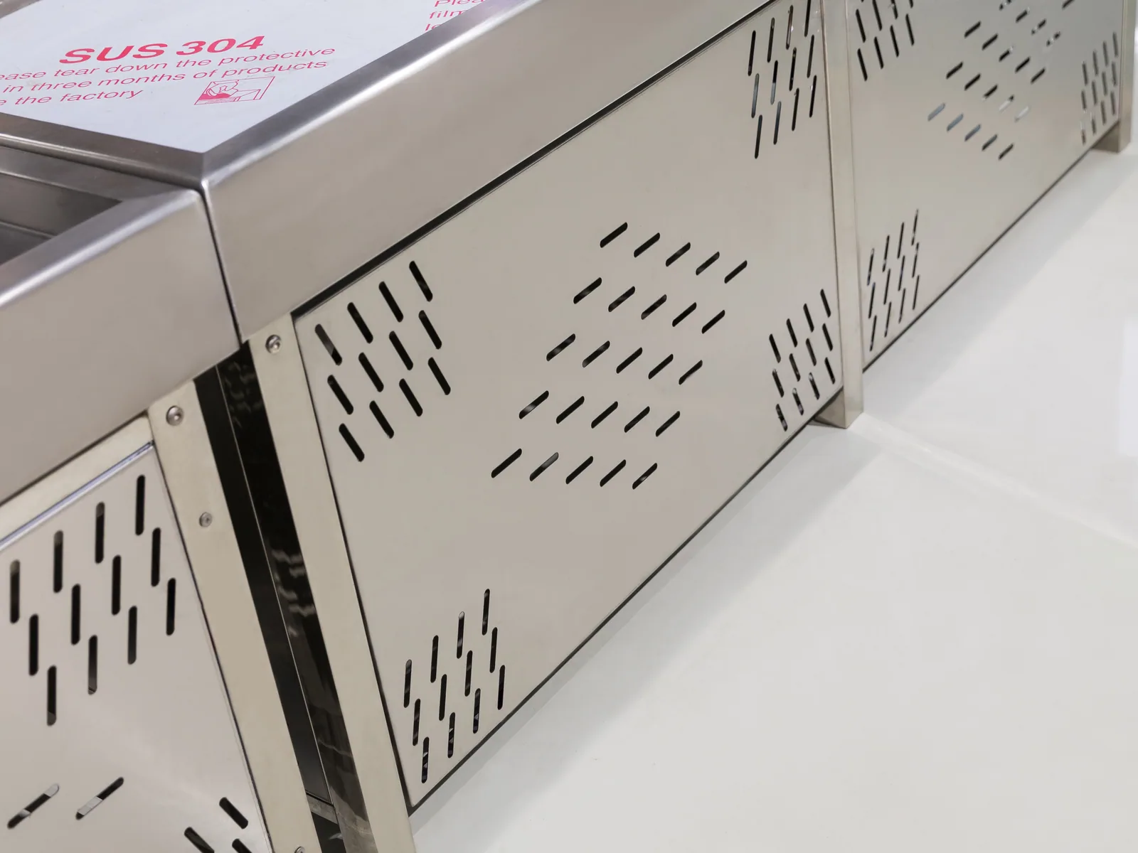 Close-up of the perforated stainless flank on a Keshun supermarket ice fresh table