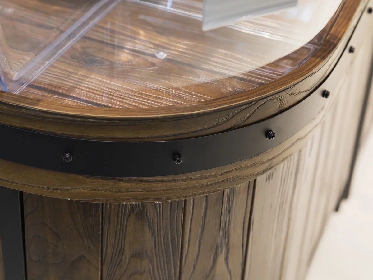 Close-up of the radiused end of the island showing the dark timber top rail wrapping the curve
