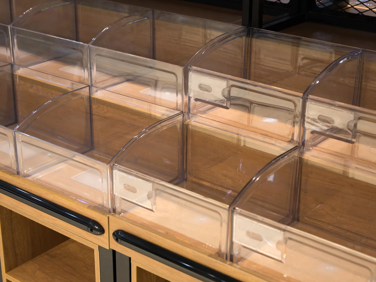 Curved end bulk island photographed from the cubby end, showing the open shelves and perforated backs