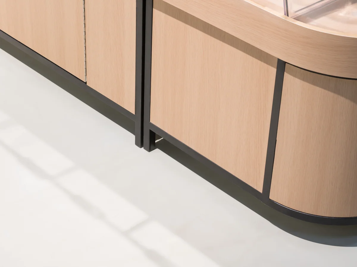 Close-up of the pale timber panel curving around the radiused end of the island