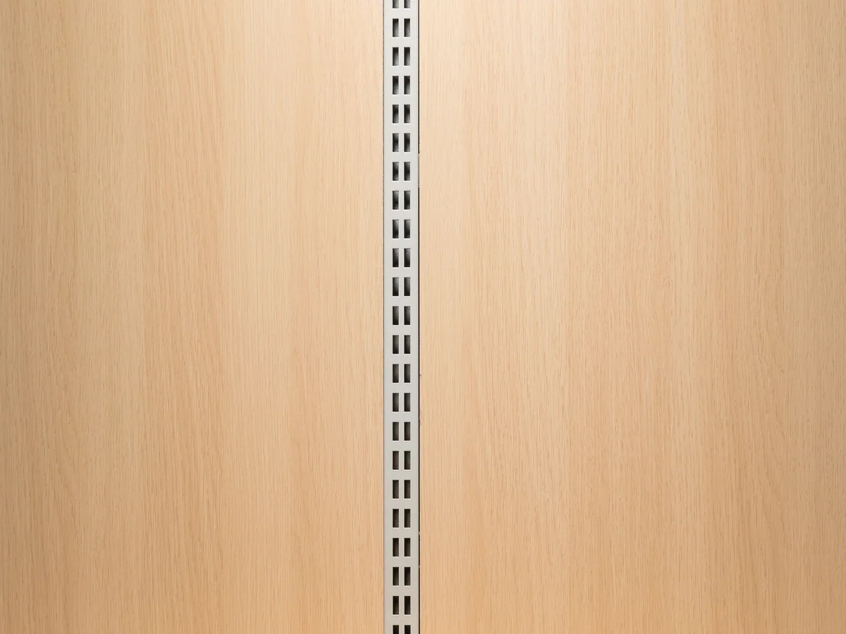 Close-up of the slotted upright column showing the regular perforation pitch