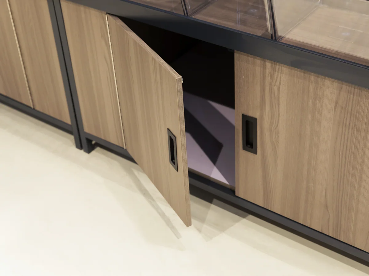 Close-up of an open cabinet door on the island base showing the empty interior