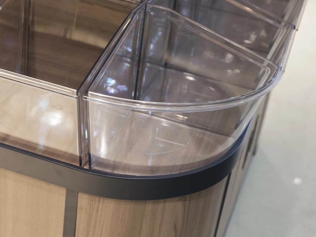 Close-up of the clear tilt bins wrapping the radiused end of the island