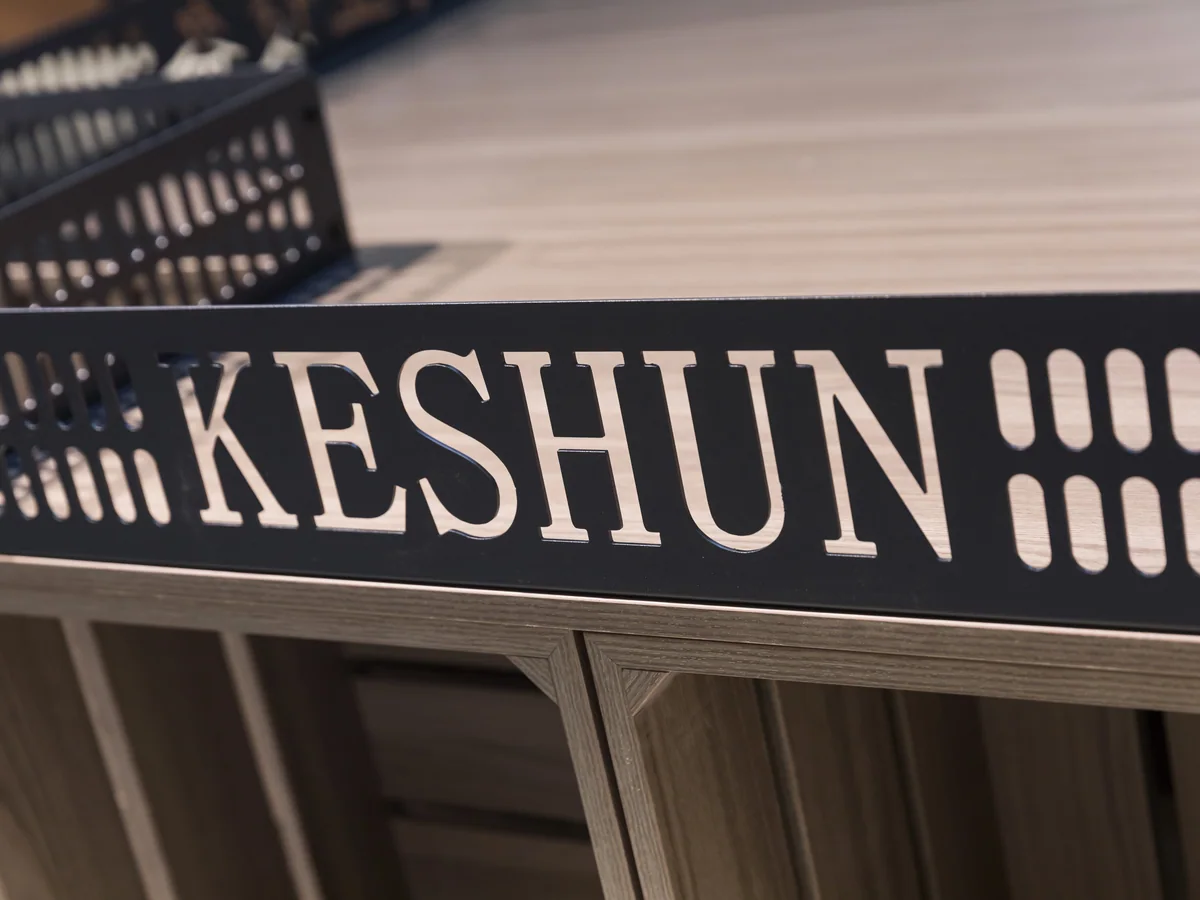 Close-up of the signage header showing the Keshun name applied to the black panel