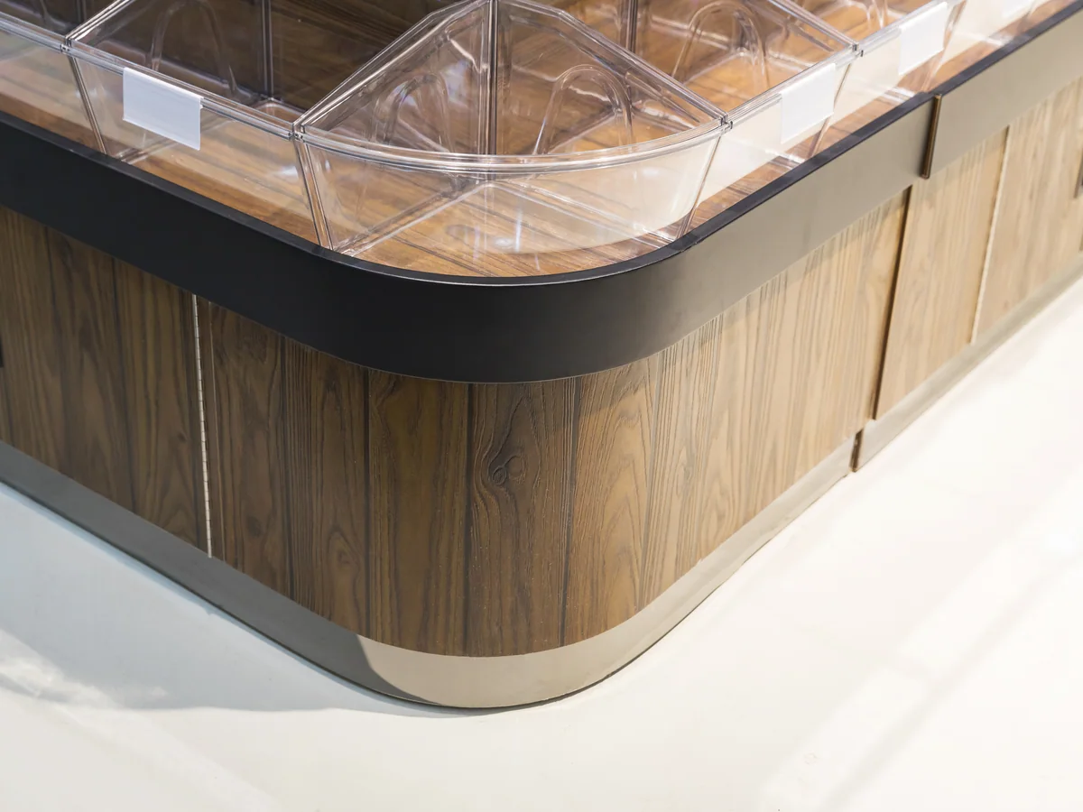 Close-up of the curved tiers of clear tilt bins with the dark cap rail above