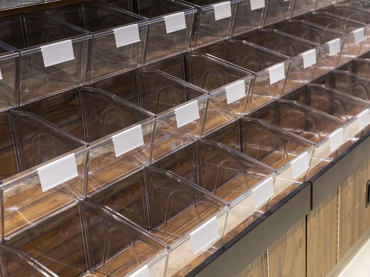 Close-up of the rows of clear tilt bins with ticket holders, photographed square on