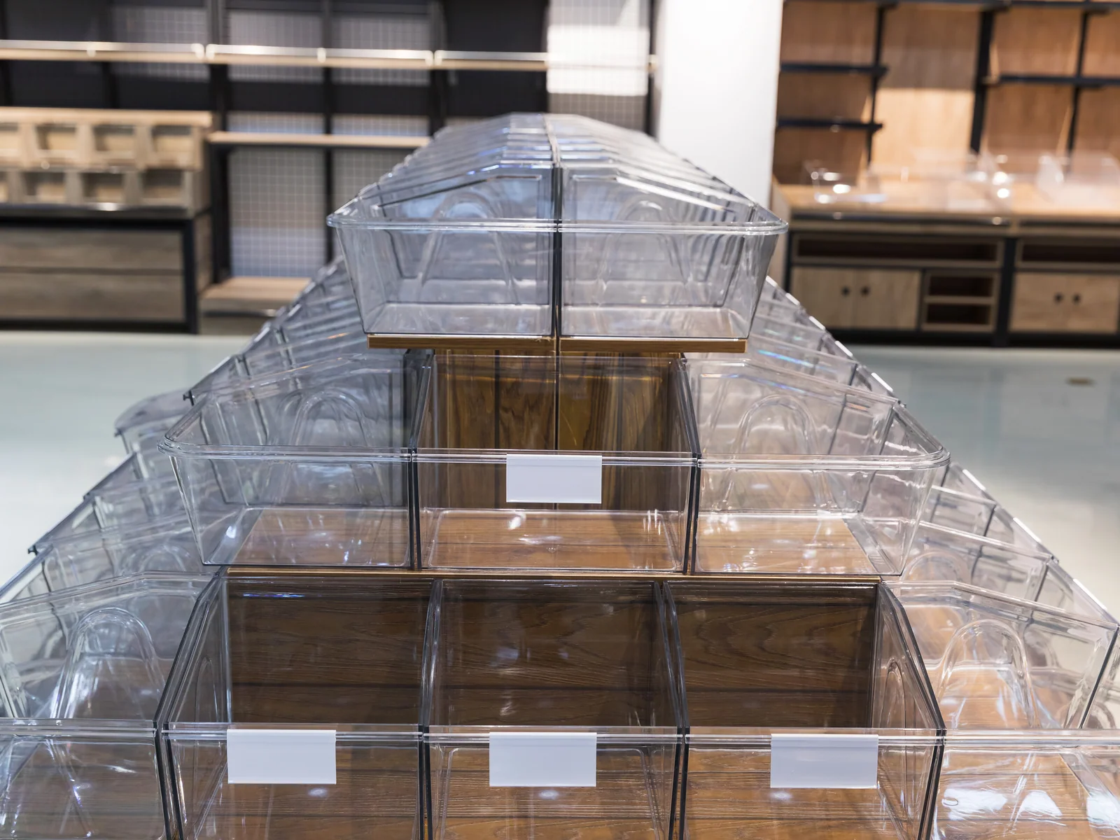 Pyramid tilt bin display photographed from the end, showing the stepped bins and the curved base