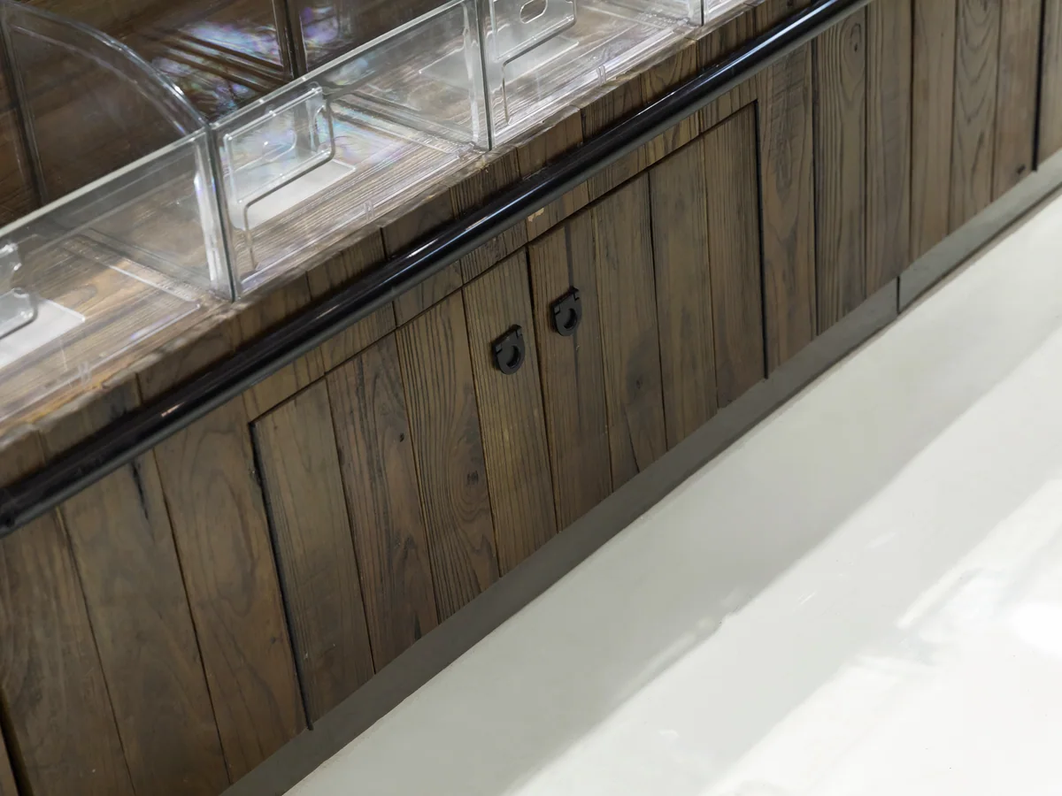 Close-up of the staved dark timber body of the tower with a cabinet door let into it