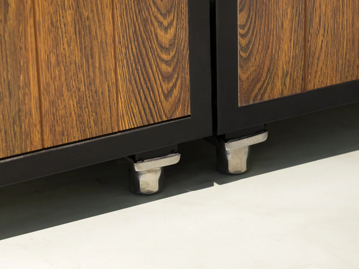 Close-up of the white adjustable levelling feet beneath the black steel frame