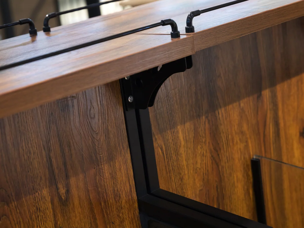 Close-up of the black bracket junction where the steel frame meets the timber top