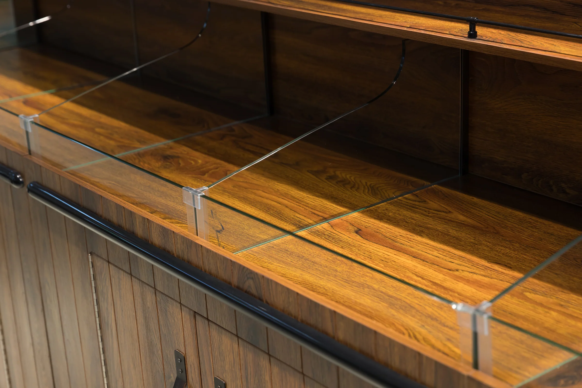 Keshun raised spine bulk island in dark timber with a canopy over the centre and radiused ends