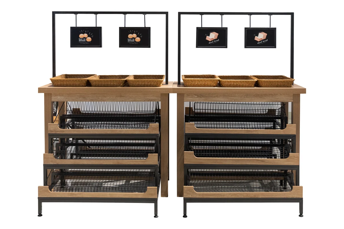 Two bays of slanted bakery bread tray racks under a shared overhead sign frame