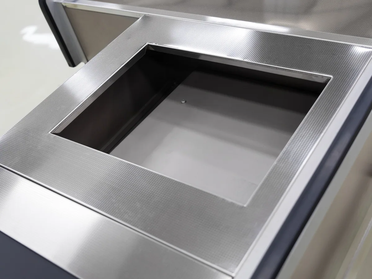 Pressed stainless well set into the worktop of a Keshun cashier counter