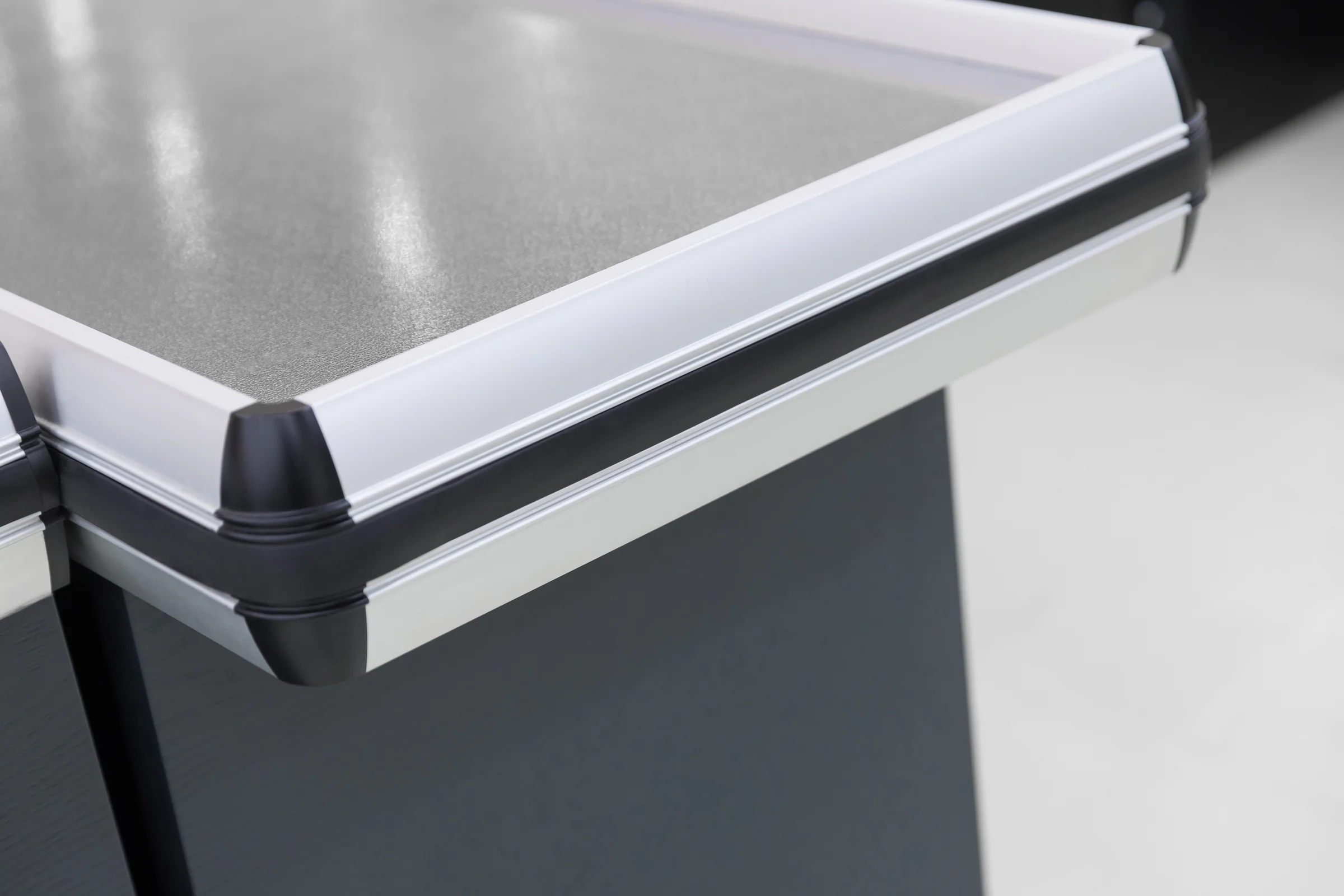 Keshun checkout counter with an X-braced timber front panel and pressed stainless worktop