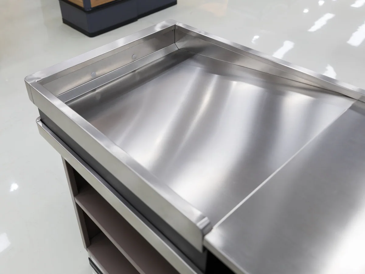Polished stainless deck and pressed well on a Keshun cashier counter