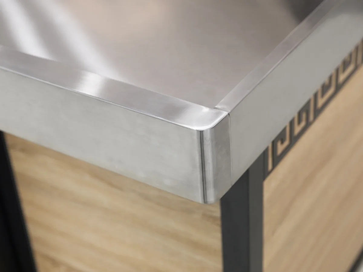 Close-up of the pressed stainless worktop meeting the oak facing