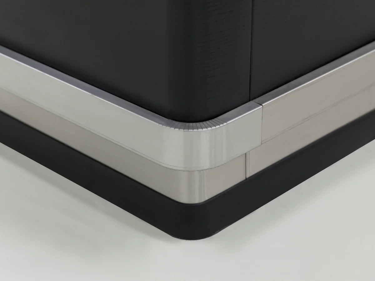 Close-up of the brushed stainless plinth band at the corner of the counter