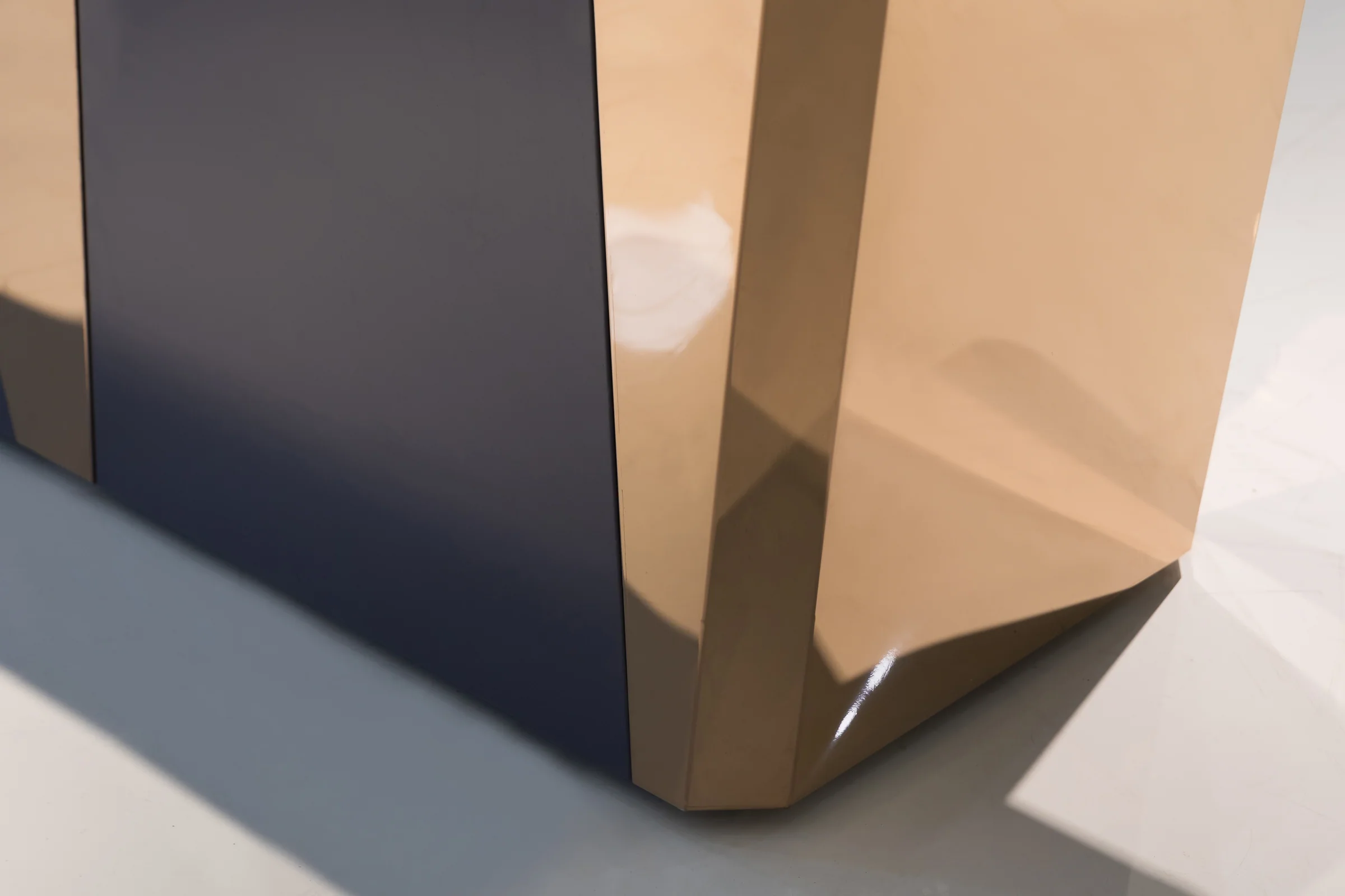 Keshun corner checkout counter in pale timber with dark angled inset panels