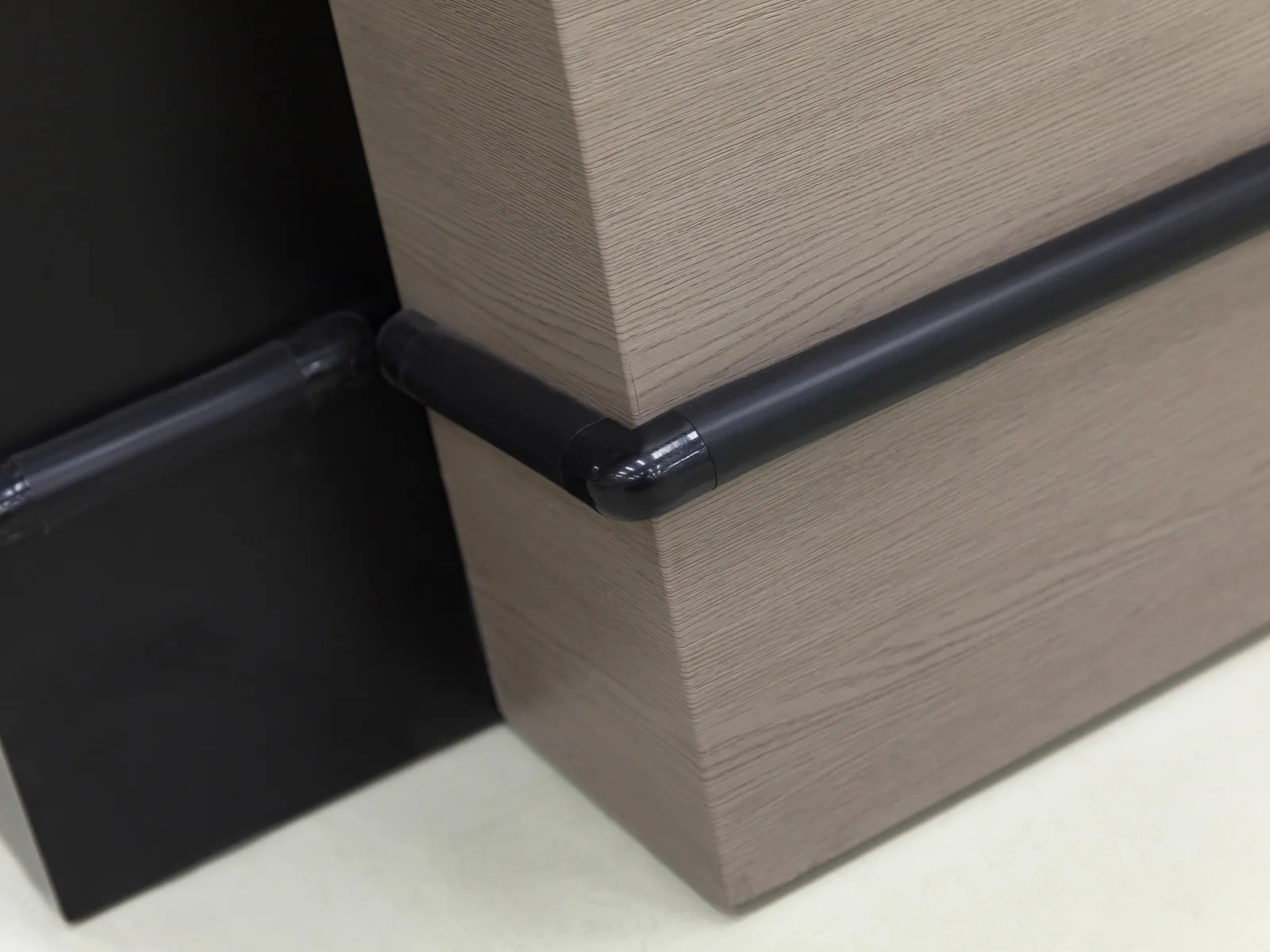 Open frame cashier counter photographed from the side, showing the unclad structure and till cabinet