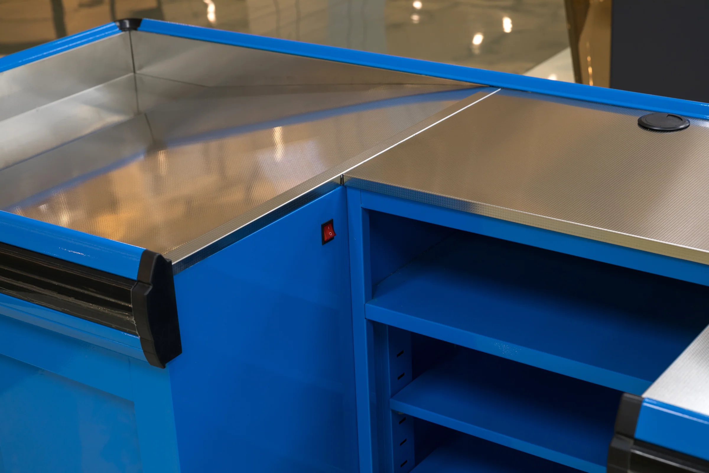 Keshun L-shaped boutique checkout counter in bright blue with dark trim and sliding base doors