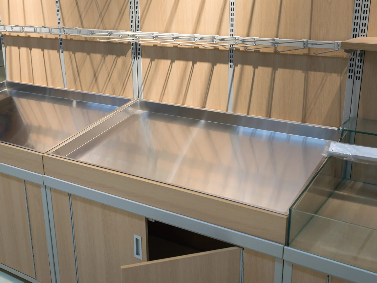 Close-up of the stainless steel base table under the shelf arms