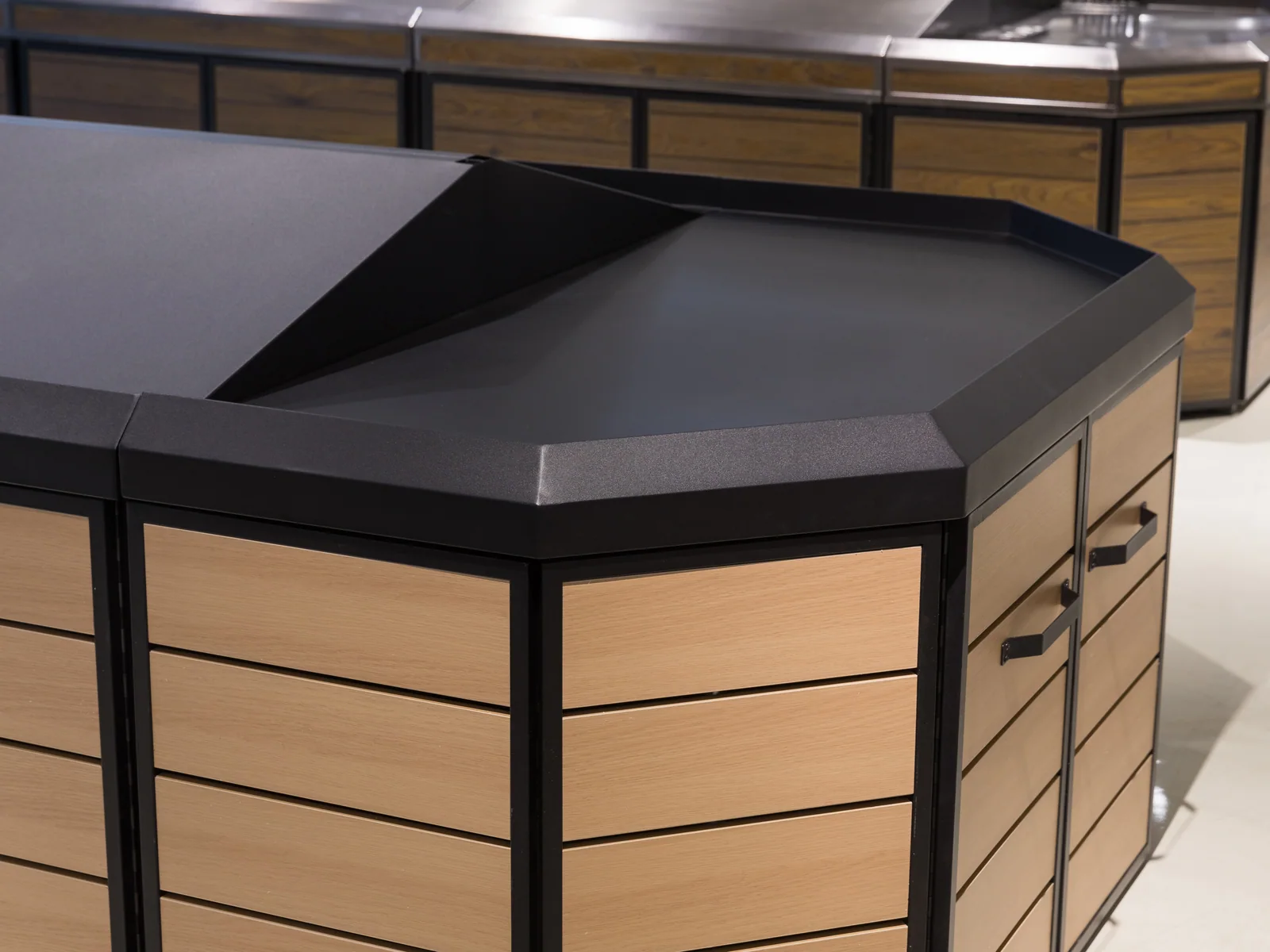 Slatted produce island table photographed from the end, showing the angled corner