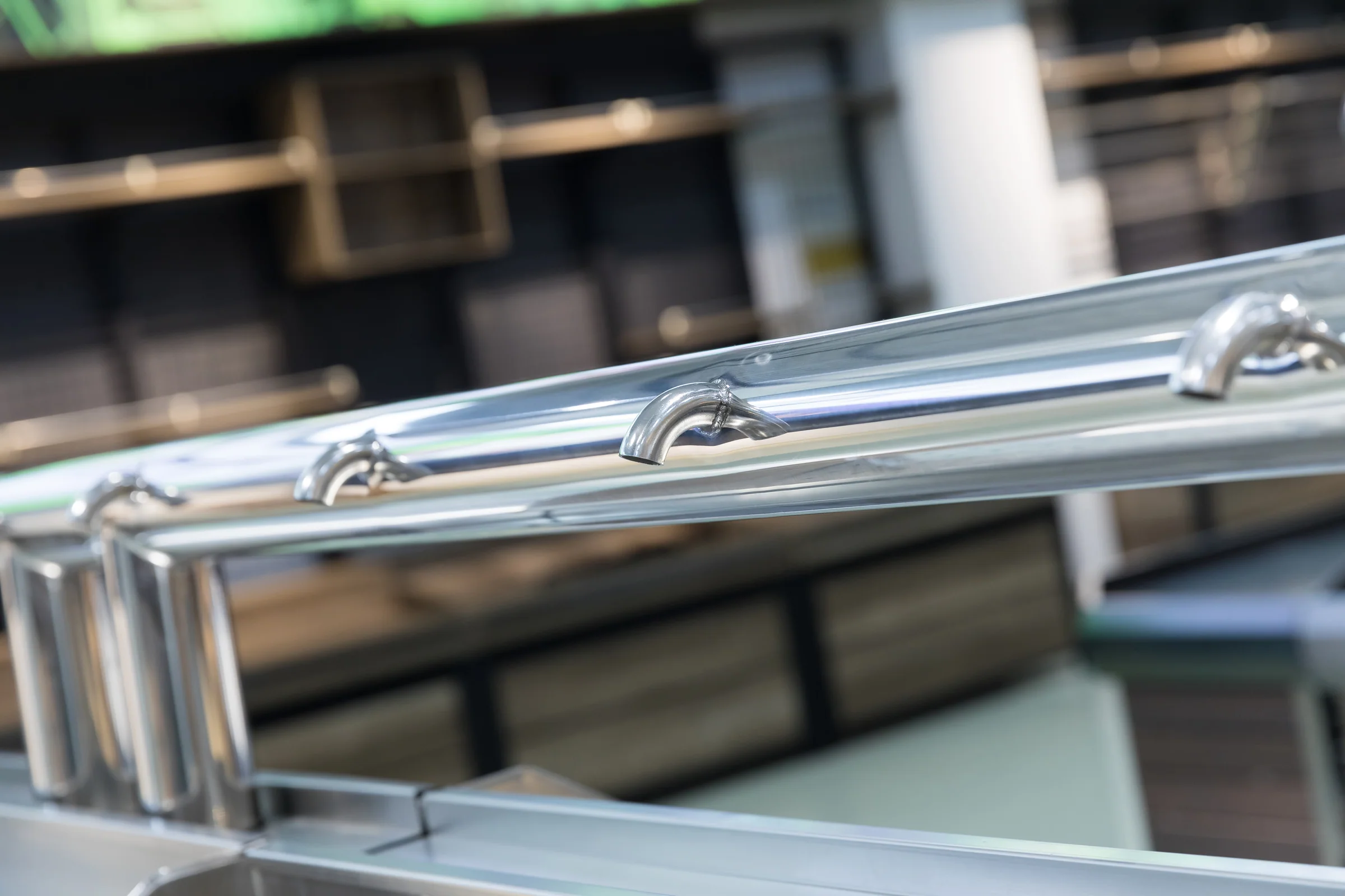 Keshun stainless topped produce island with an overhead rail on posts over a timber base