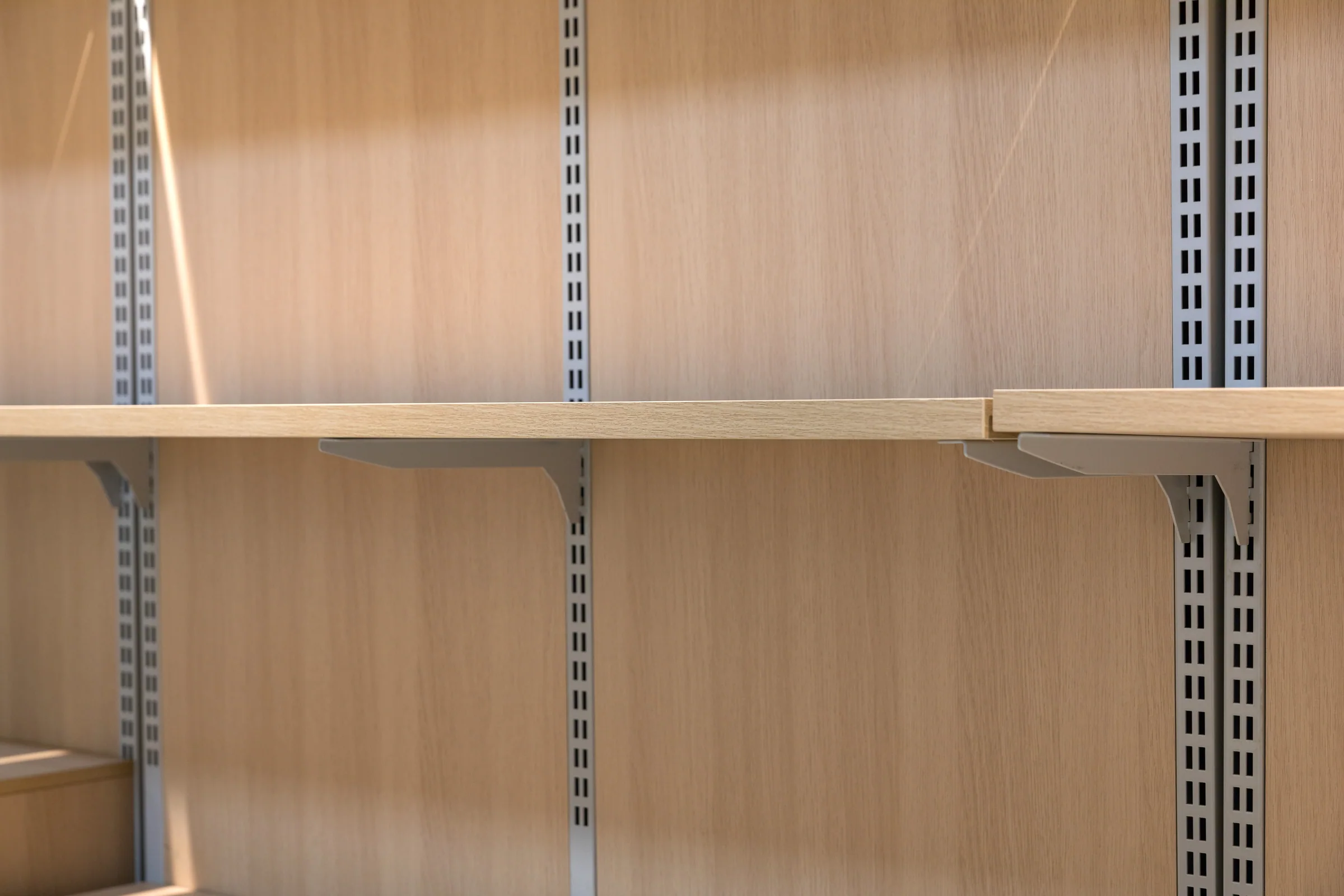Keshun single sided wall grain shelving with pale timber shelves and an open sack base