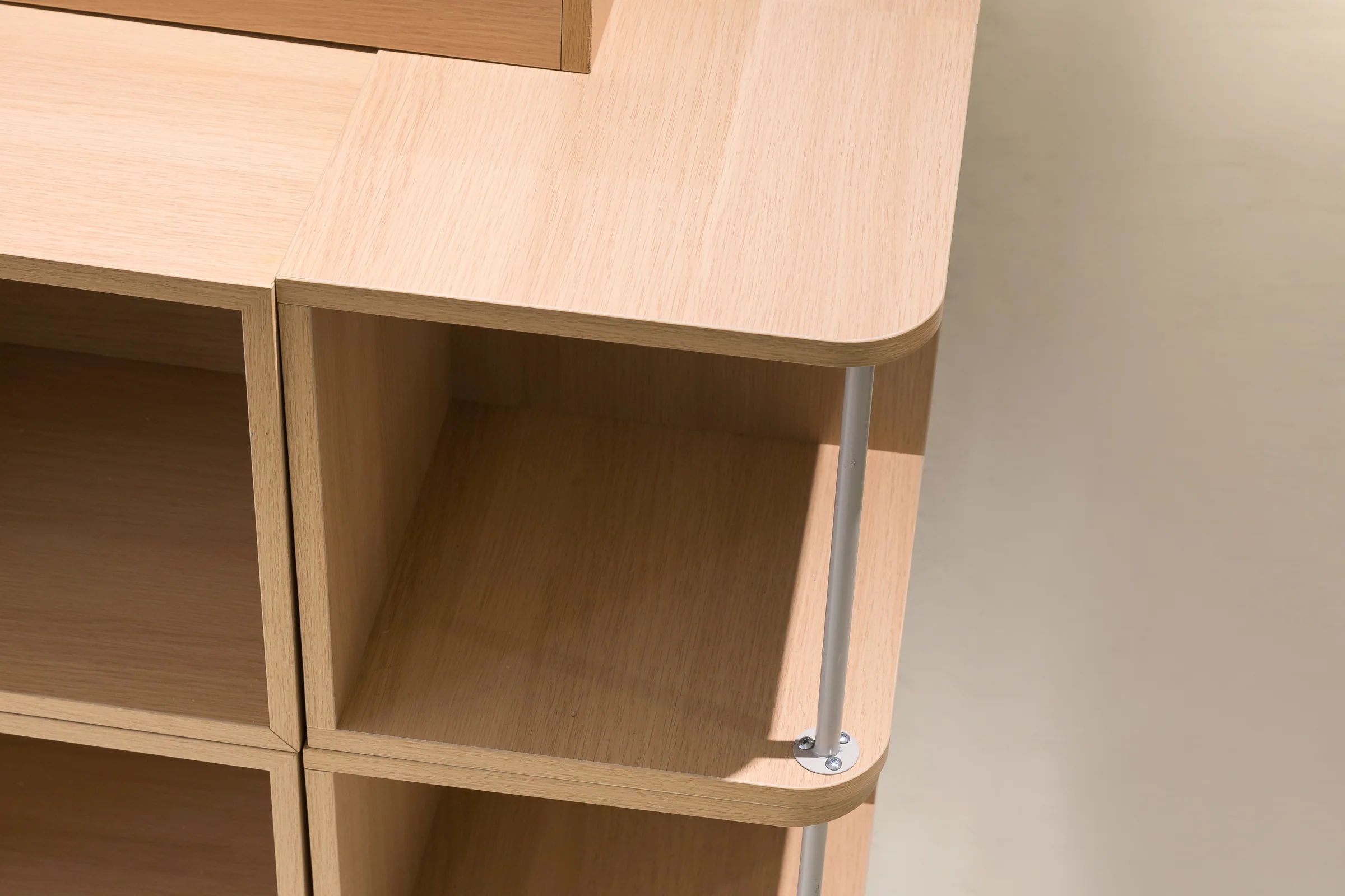 Keshun large pale timber promotional island with a raised platform over open cubbies