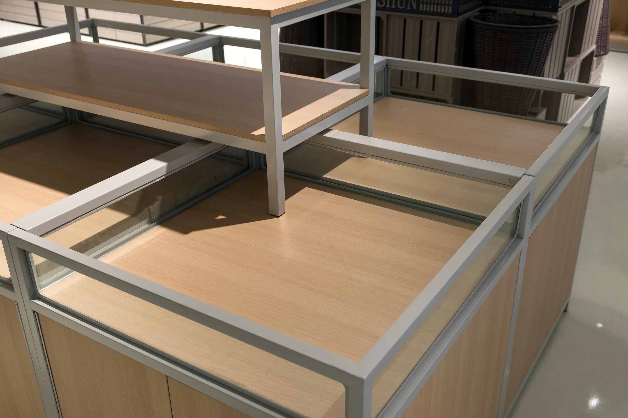 Keshun square promotional island with a glazed display top over a pale timber base