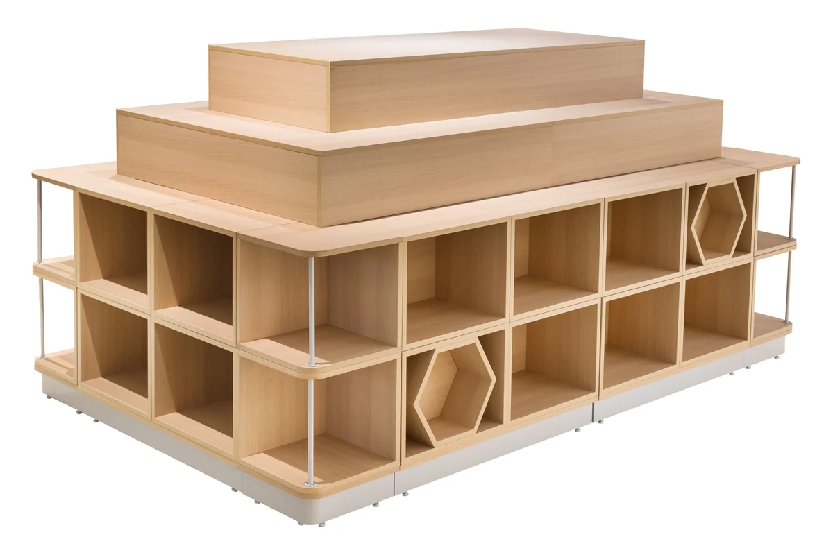 Light timber stepped supermarket promotion island with open cubby storage through the base