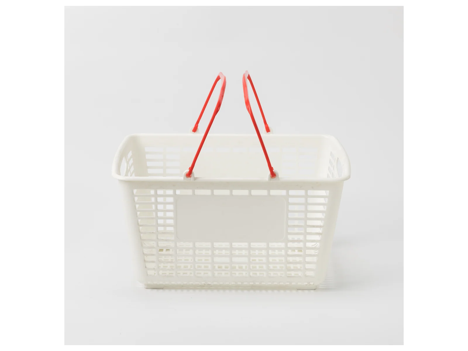 White Hand Basket with Red Handles on a white studio background