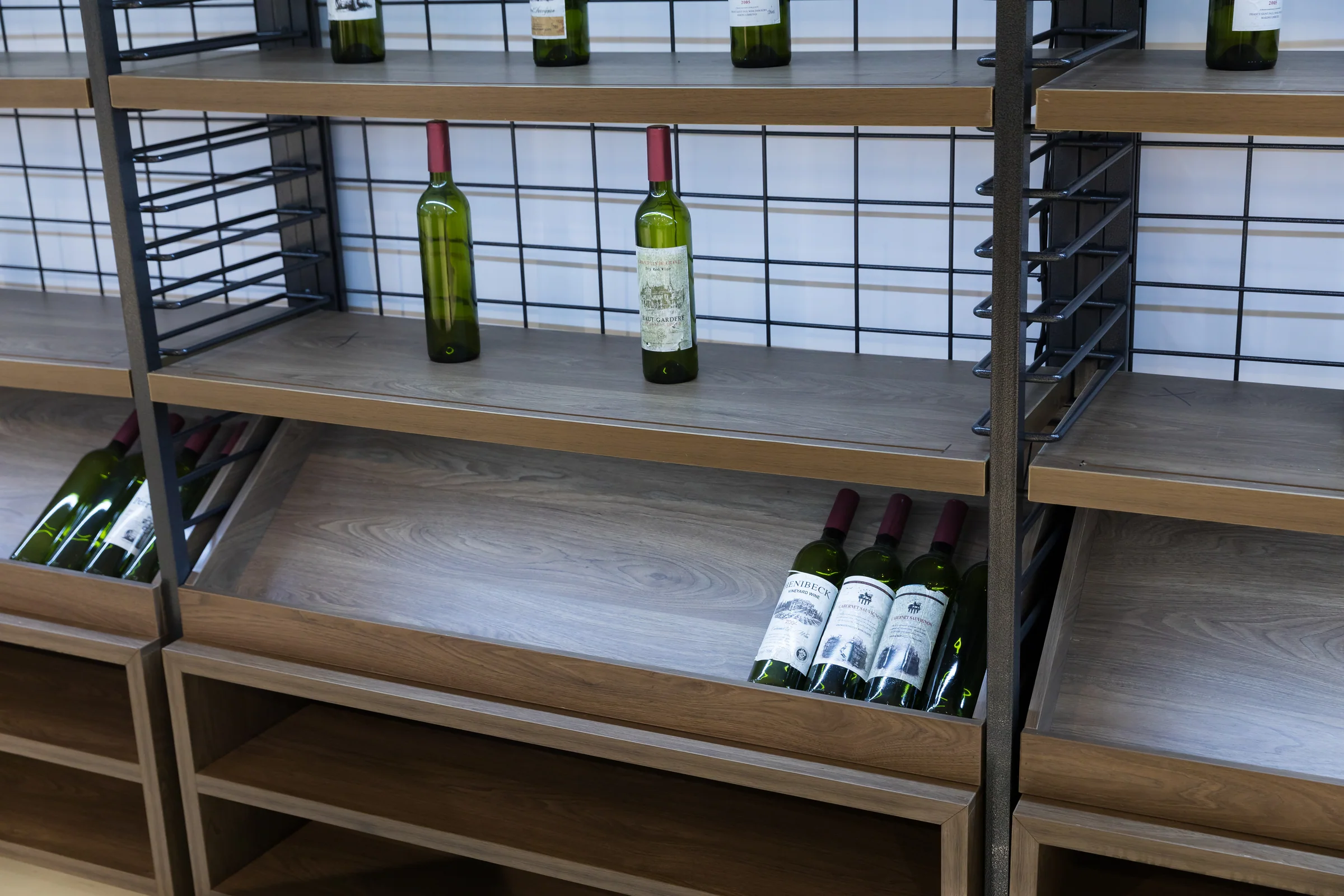 Keshun tobacco showcase with a fine compartment grid in a black steel frame over a timber base