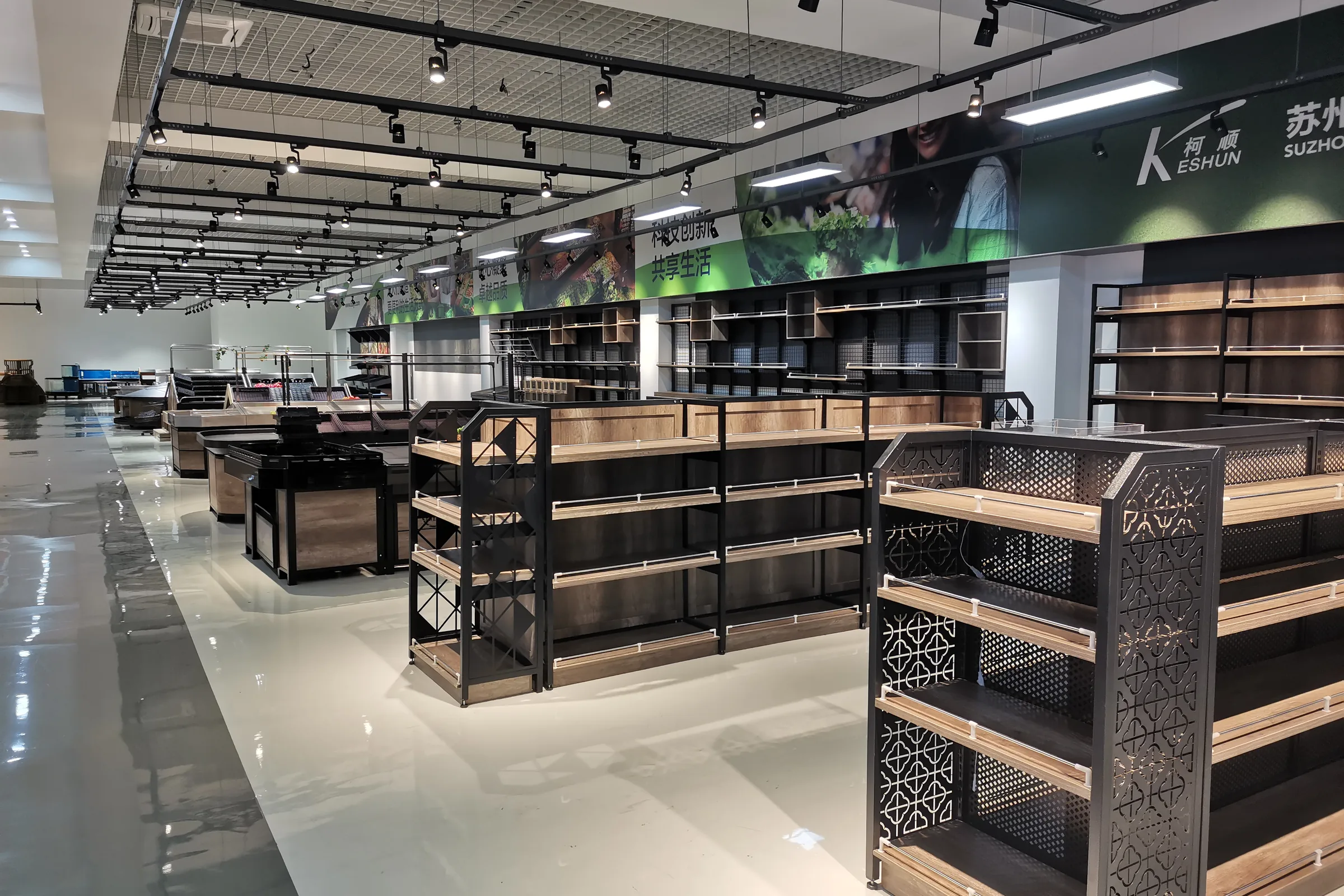 Keshun showroom aisle with steel and wood shelving bays, produce islands and checkout counters