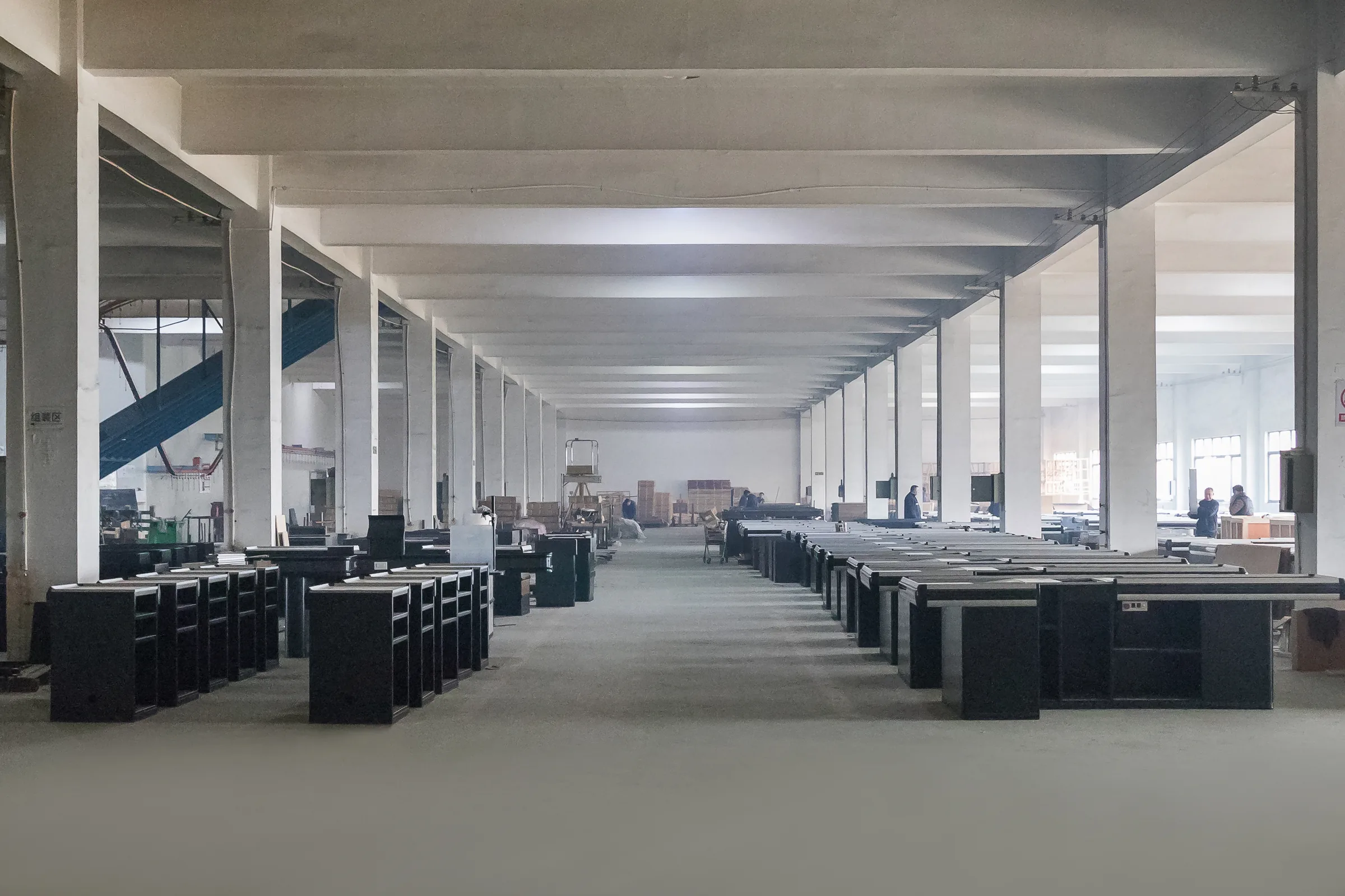 Long workshop aisle at the Keshun plant in Changshu with finished supermarket checkout counters staged in rows down both sides